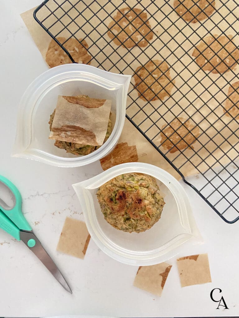 Two freezer-safe silicone containers with cooked food inside them.
