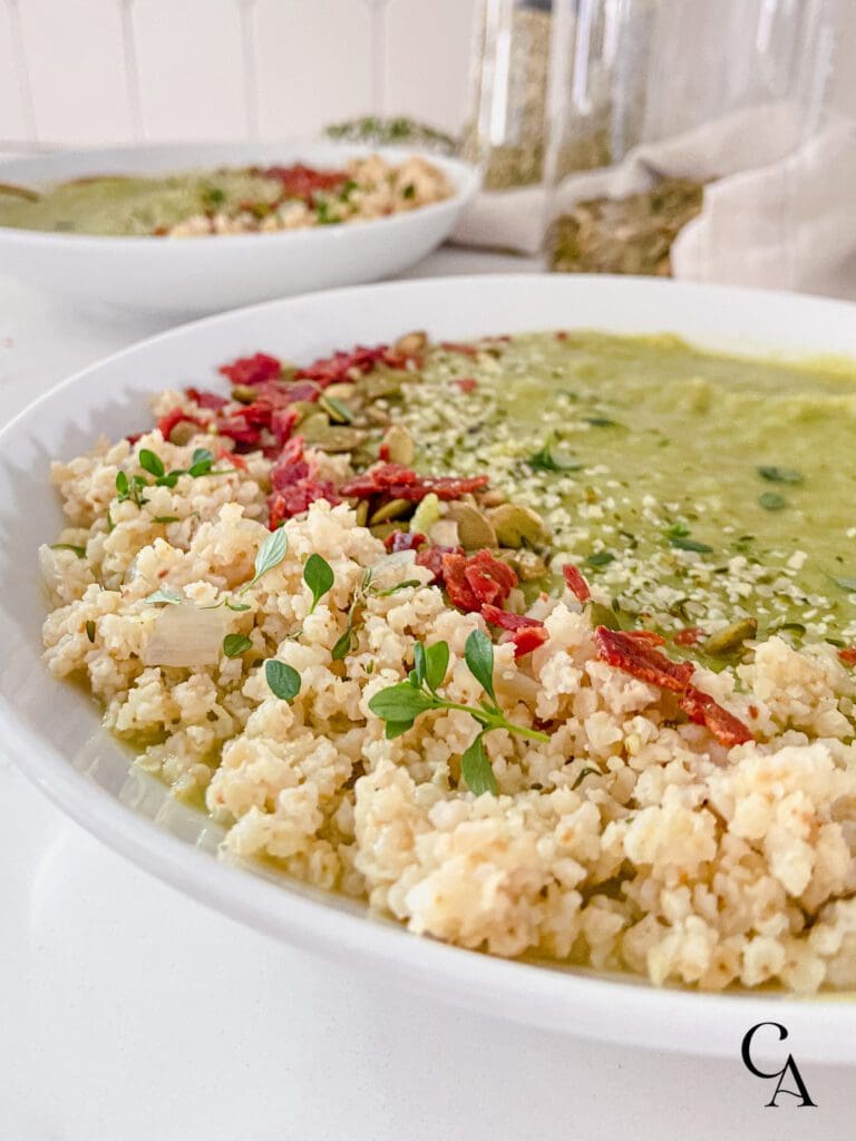 A bowl of green soup with savory millet topping.