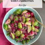 Brussels sprouts and cranberries in a turquoise serving bowl.