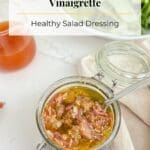 Salad dressing in a small jar on a white counter.