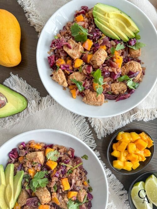 Ginger chicken bowls with mango and lime wedges.
