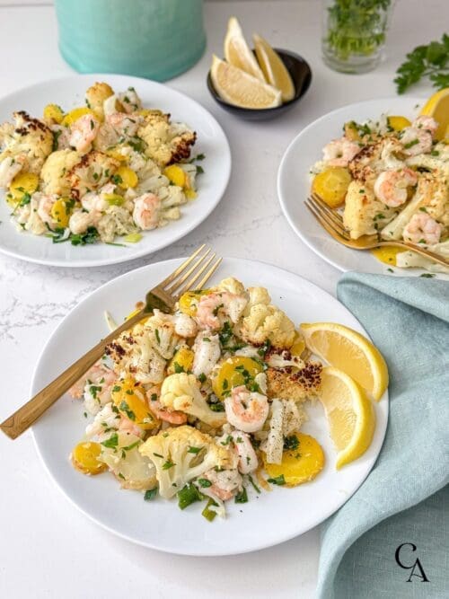 Plates of shrimp dinner with gold forks.