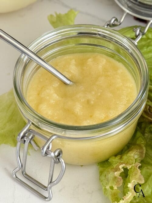 A small jar of homemade salad dressing with sweet onions and avocado oil.