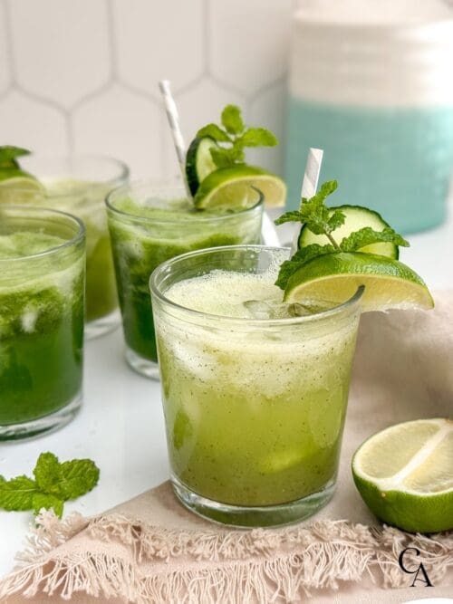 Glasses of cucumber lime water garnished with mint leaves.