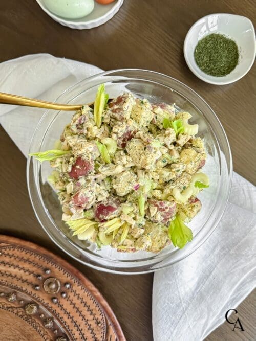 A bowl of healthy potato salad with avocado oil mayo, dill and celery leaves.