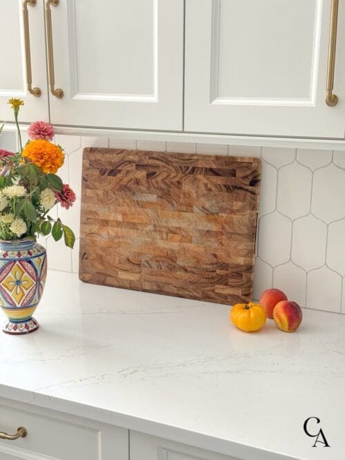 An acacia cutting board in a white kitchen.