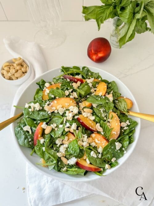 A green salad with fruit and feta cheese.