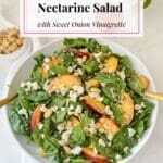 A nectarine salad with spinach, nuts, and goat cheese.