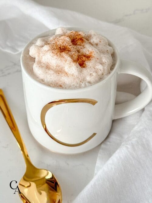 A cinnamon milk latte in a white mug.