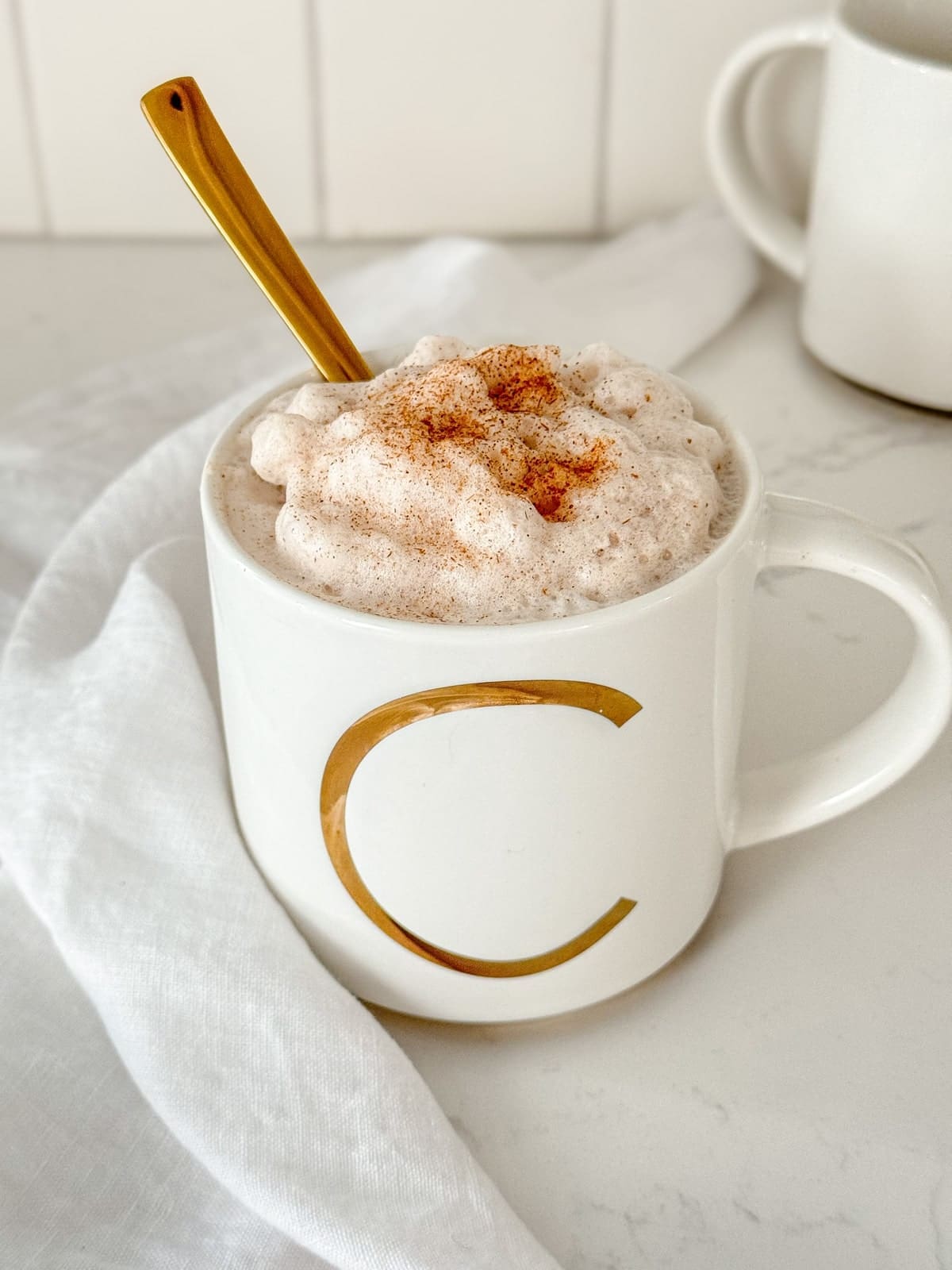 A white mug of cinnamon milk.