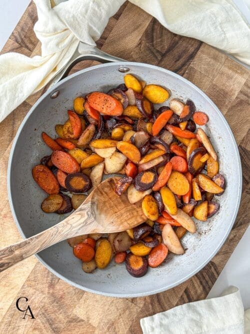 Sautéed carrots in skillet with a linen napkin.