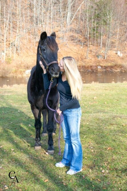 A young woman kissing her beloved horse.