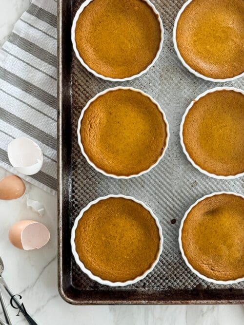 Pumpkin custards on a rimmed baking sheet.