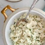 Cauliflower mash with chives and a silver spoon.