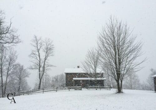 A log cabin covered in snow.