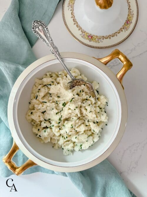 A bowl of mashed cauliflower with chives.