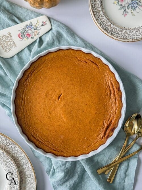 A crustless pumpkin pie on a white table.