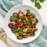 A bowl of stir-fried veggies with shrimp.