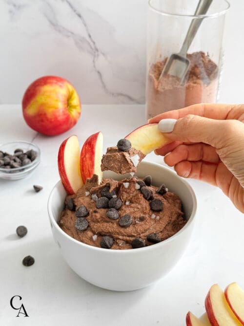 A piece of apple with hummus and chocolate chips.