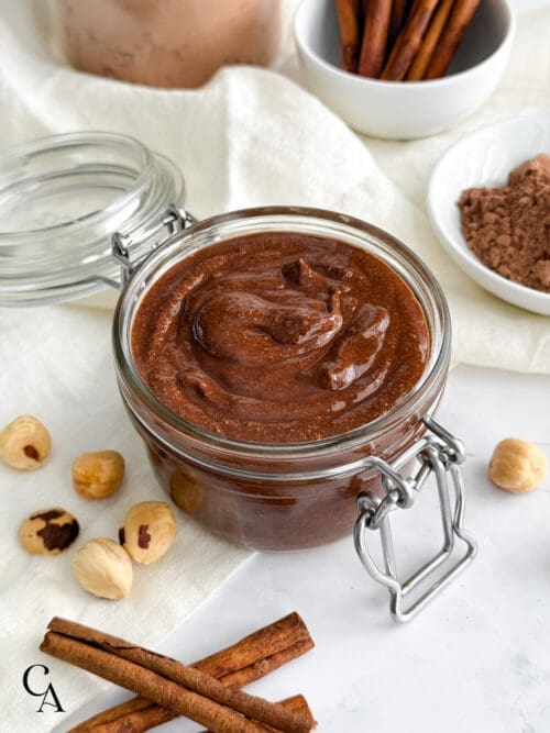 A jar of chocolate hazelnut spread on a white counter.